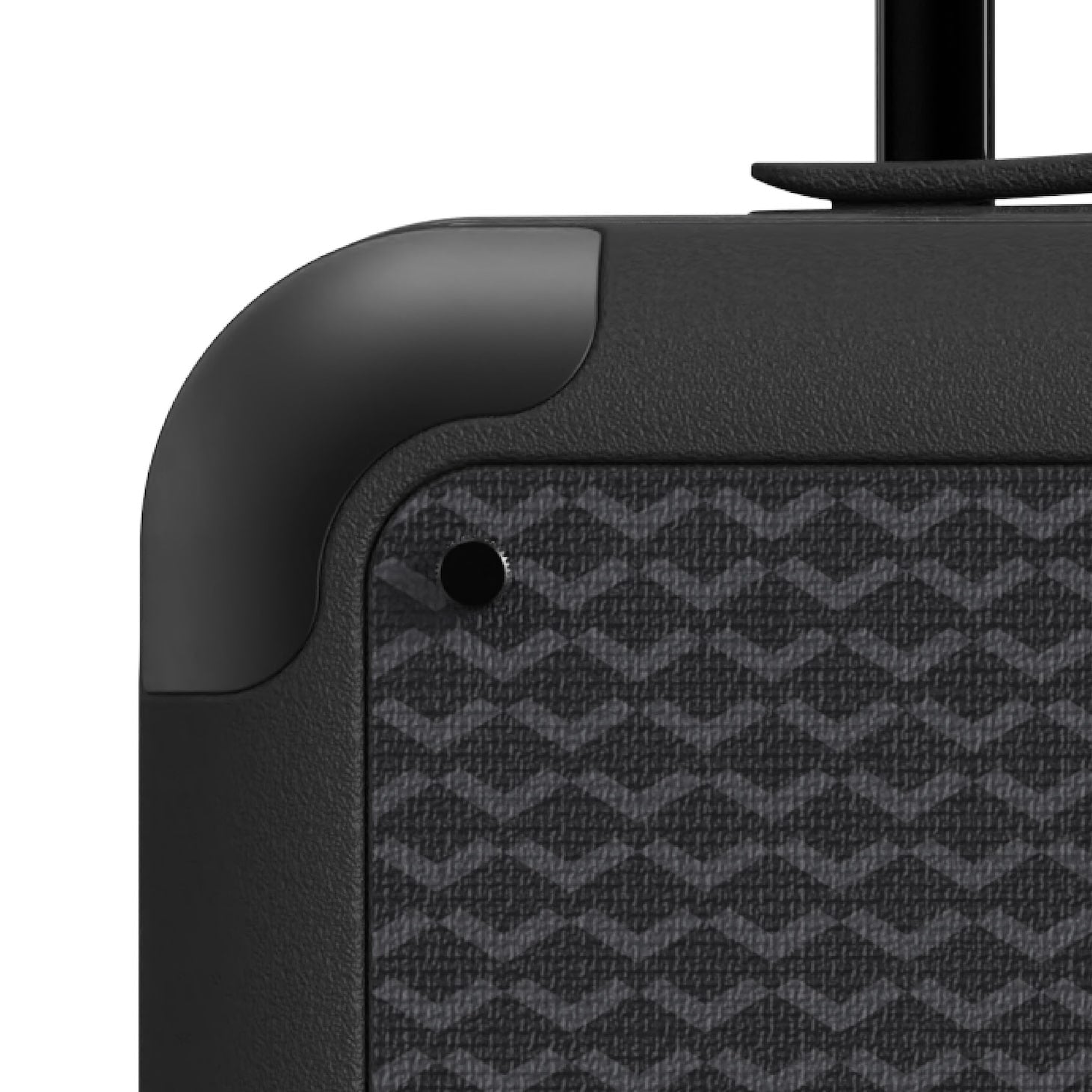 Close-up of black carry-on luggage corner with aluminum bumper protection and textured canvas panel