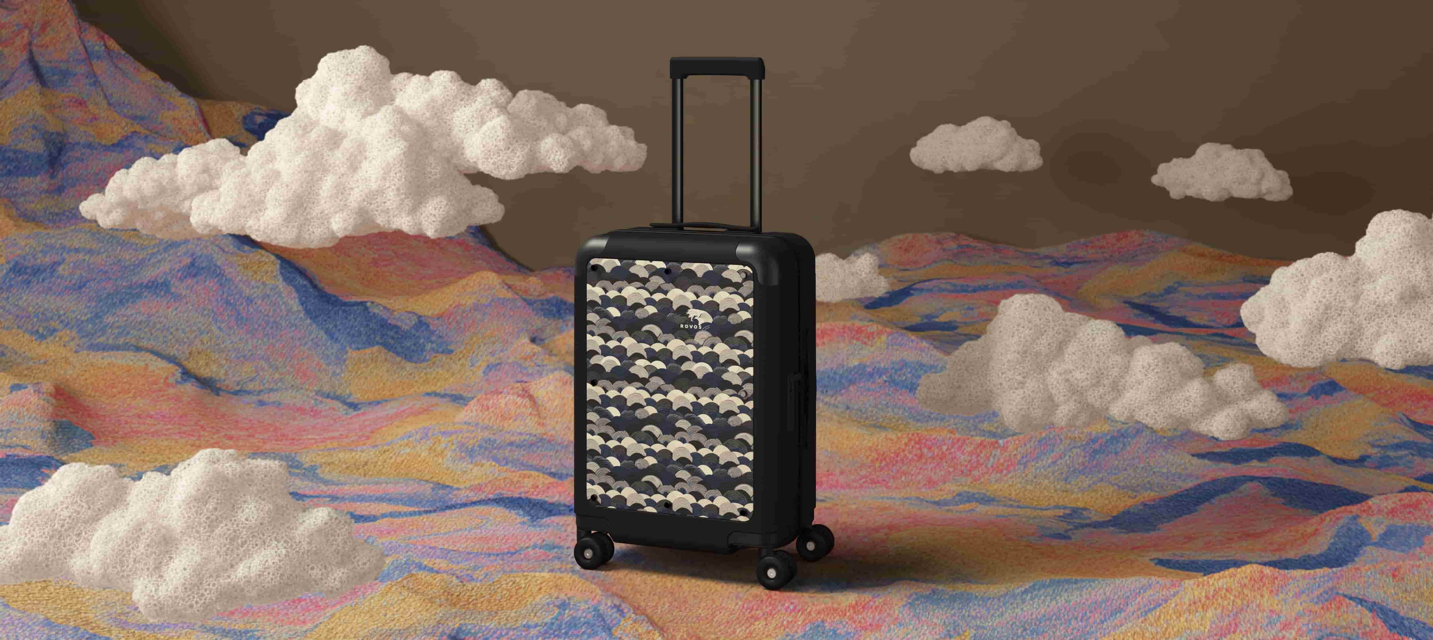 Black designer carry-on luggage with textured canvas front set against a vibrant, surreal cityscape illustration